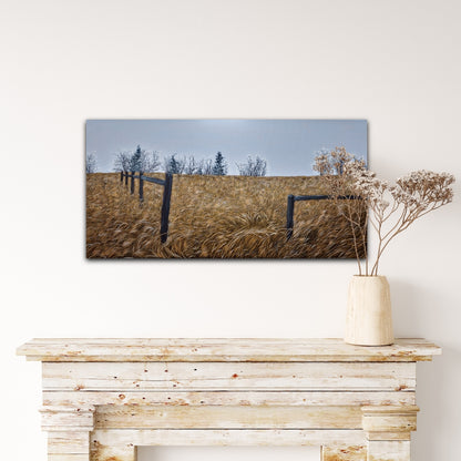 Framed landscape print of a field with trees on a wall above a wooden console table.