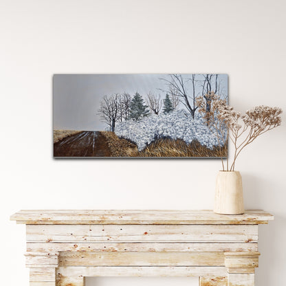 Winter landscape painting on a wall above a wooden console table with a vase of dried flowers.