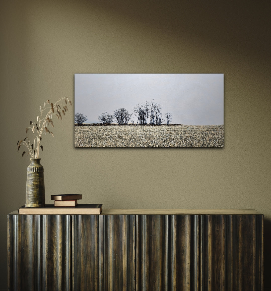 Finter 18"x36" oil painting of a field with winter trees and a blue-grey horizon on a green wall
