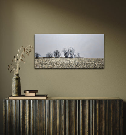 Finter 18"x36" oil painting of a field with winter trees and a blue-grey horizon on a green wall