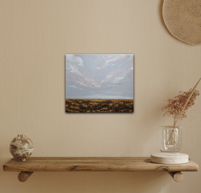 Breathe-oil landscape painting of a soft sky and flat prairie in fall all gold and brown on a yellow wall