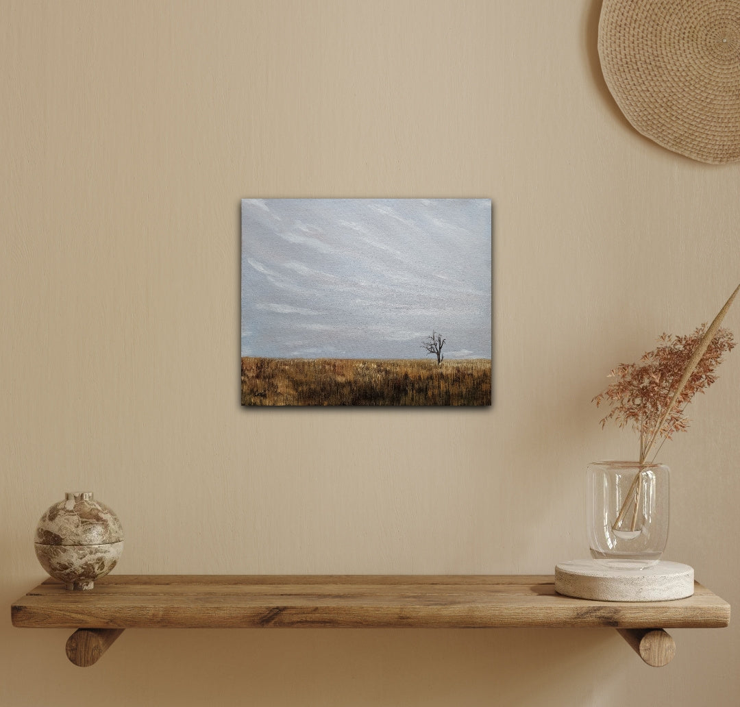  oil landscape painting of a single solo tree in a golden fall field under a grey/blue sky on a yellow wall