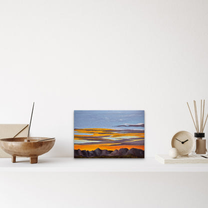 Abstract landscape painting on a white wall with decorative items below.