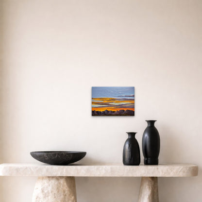 Small abstract painting on a wall above a marble ledge with two black vases and a bowl.