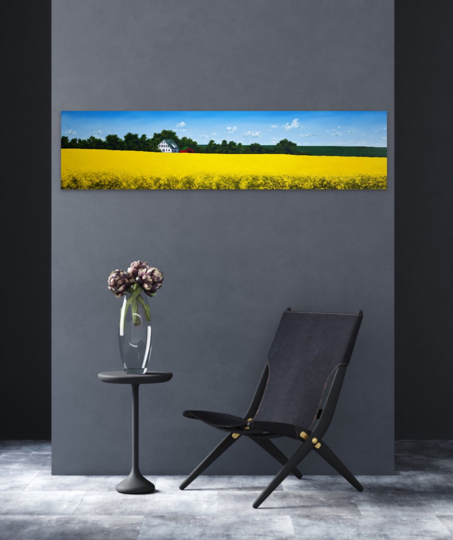 Modern interior with a black chair, small table, and vase against a gray wall with a large painting of a yellow field.