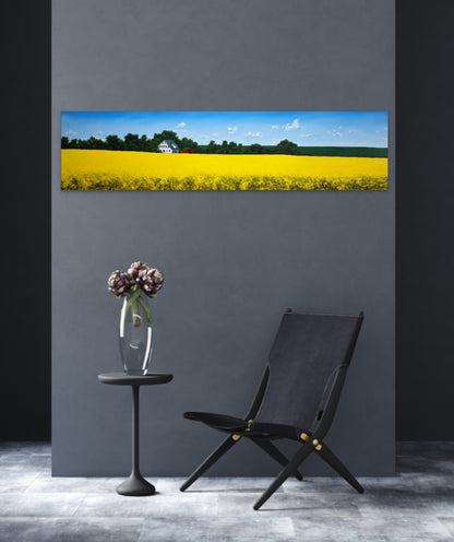 Modern interior with a black chair, small table, and vase against a gray wall with a large painting of a yellow field.