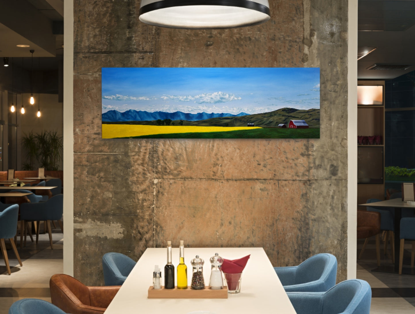 Panoramic landscape painting on a textured wall in a modern restaurant setting.
