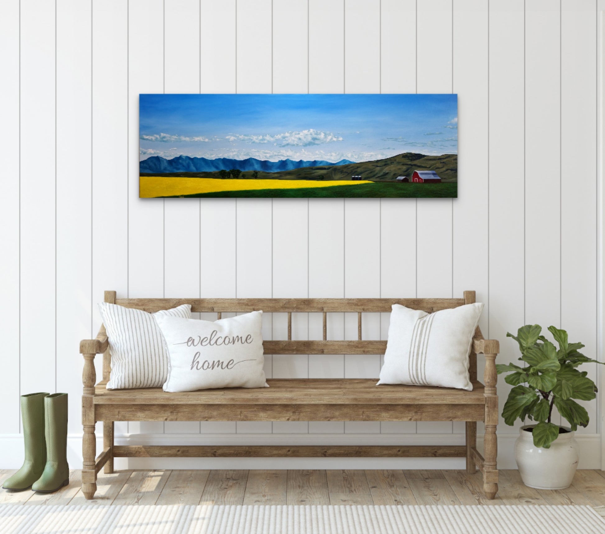 Wooden bench with decorative pillows in a room with a large landscape painting on the wall.