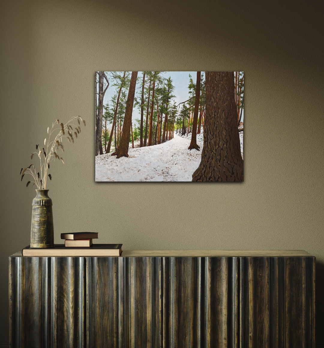 Framed forest scene on a wall above a console table with decorative items.