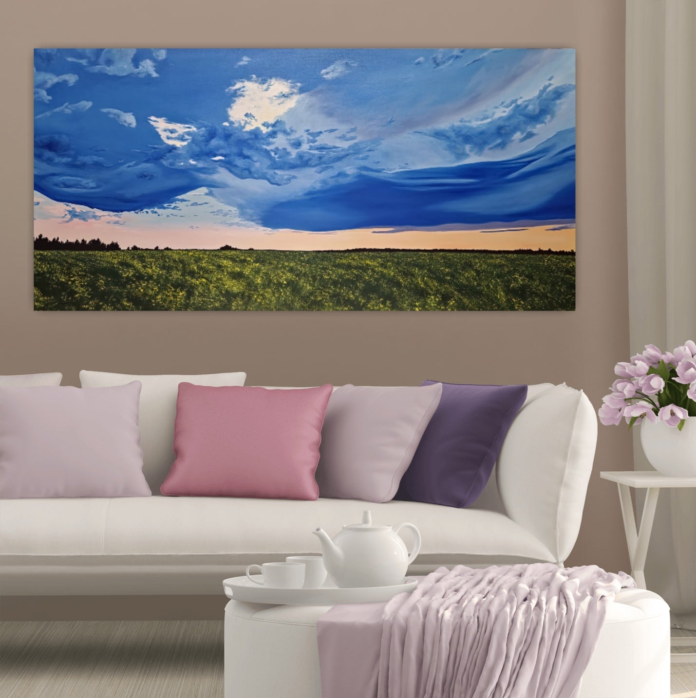 Golden Hour Affirmation is an original oil painting by Christina Gouldsborough of a vibrant stormy sky with a sunset over a canola field on a wall over a white couch and purple and pink cushions